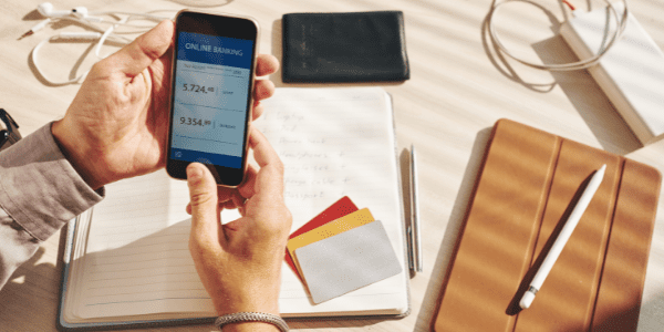Person holding a smart phone with a budgeting app pulled up
