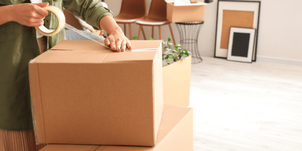 a woman taping up her moving box
